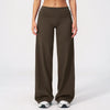 A model is wearing dark brown flared high-waist yoga pants with white and gray athletic shoes.