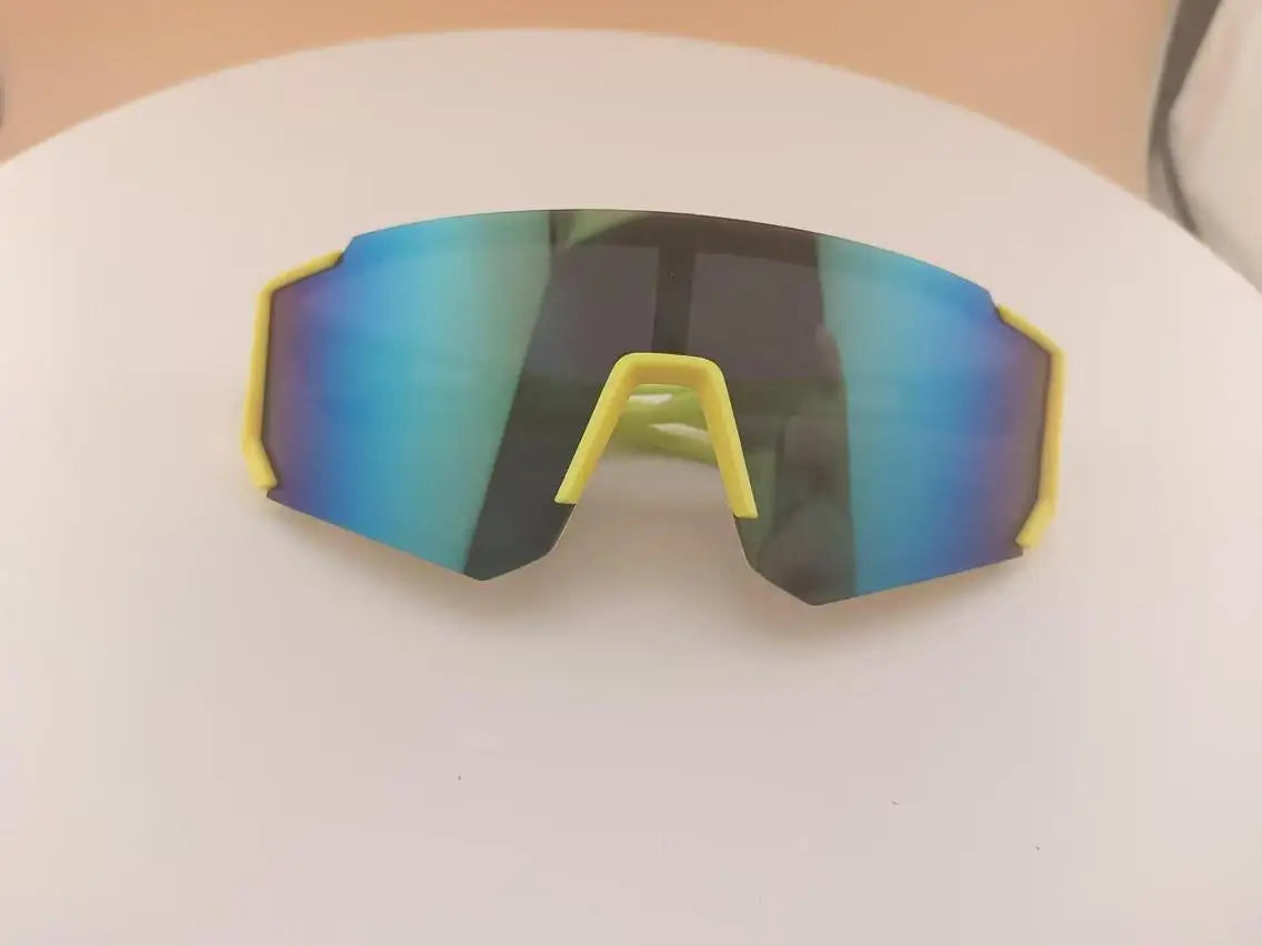 A pair of yellow-framed sports sunglasses with blue mirrored lenses resting on a white surface.