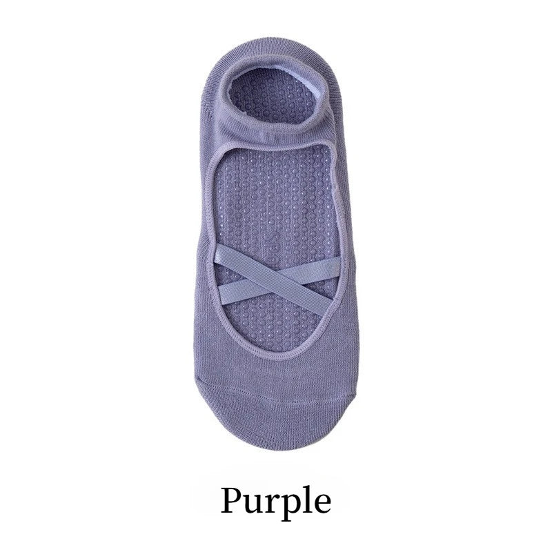 A pair of purple crisscross strap yoga socks.