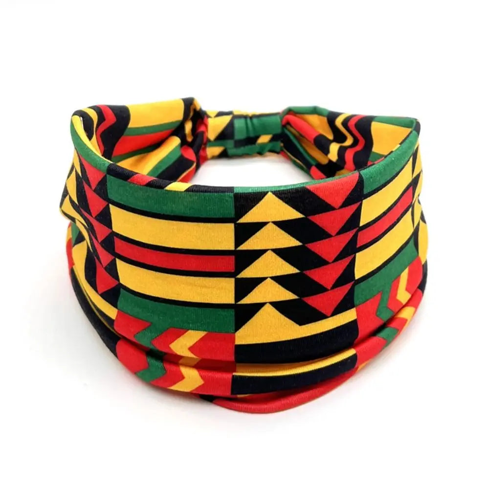 Un large bandeau pour cheveux avec un imprimé géométrique vibrant de rayures jaune, vert, rouge et noir.