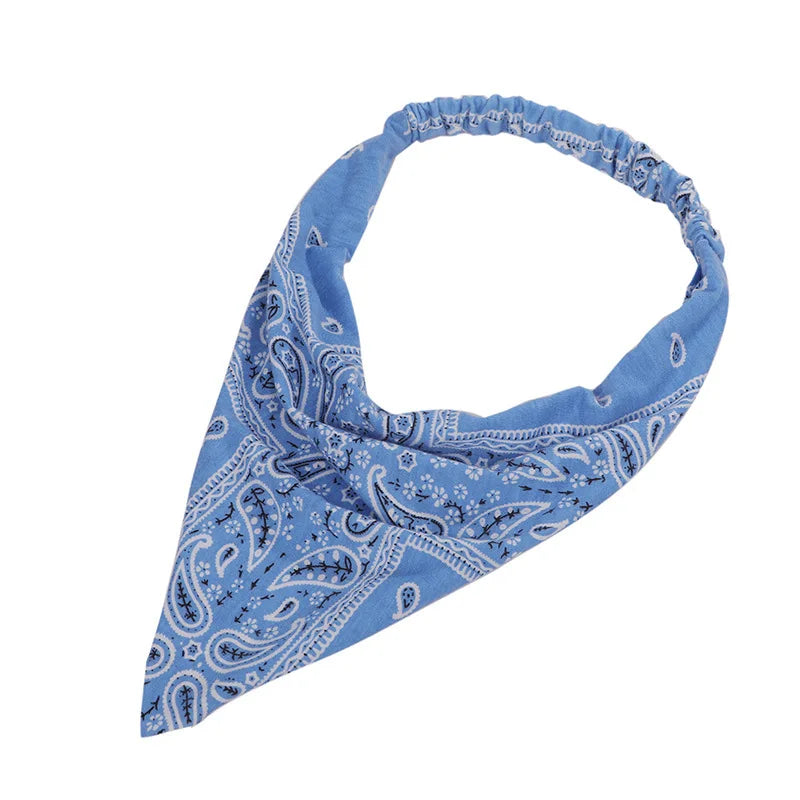 Pañuelo triangular estilo boho paisley azul claro atado al cuello.