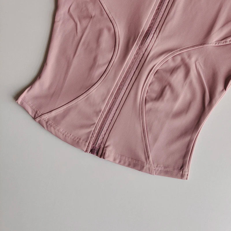 A close-up view of a mauve quick-dry yoga and fitness jacket with a visible zipper detail.