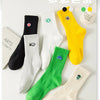 A collection of men's athletic embroidered crew socks in various colors including black, white, yellow, and green.