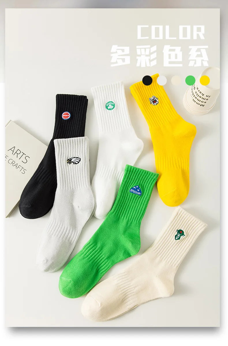 A collection of men's athletic embroidered crew socks in various colors including black, white, yellow, and green.