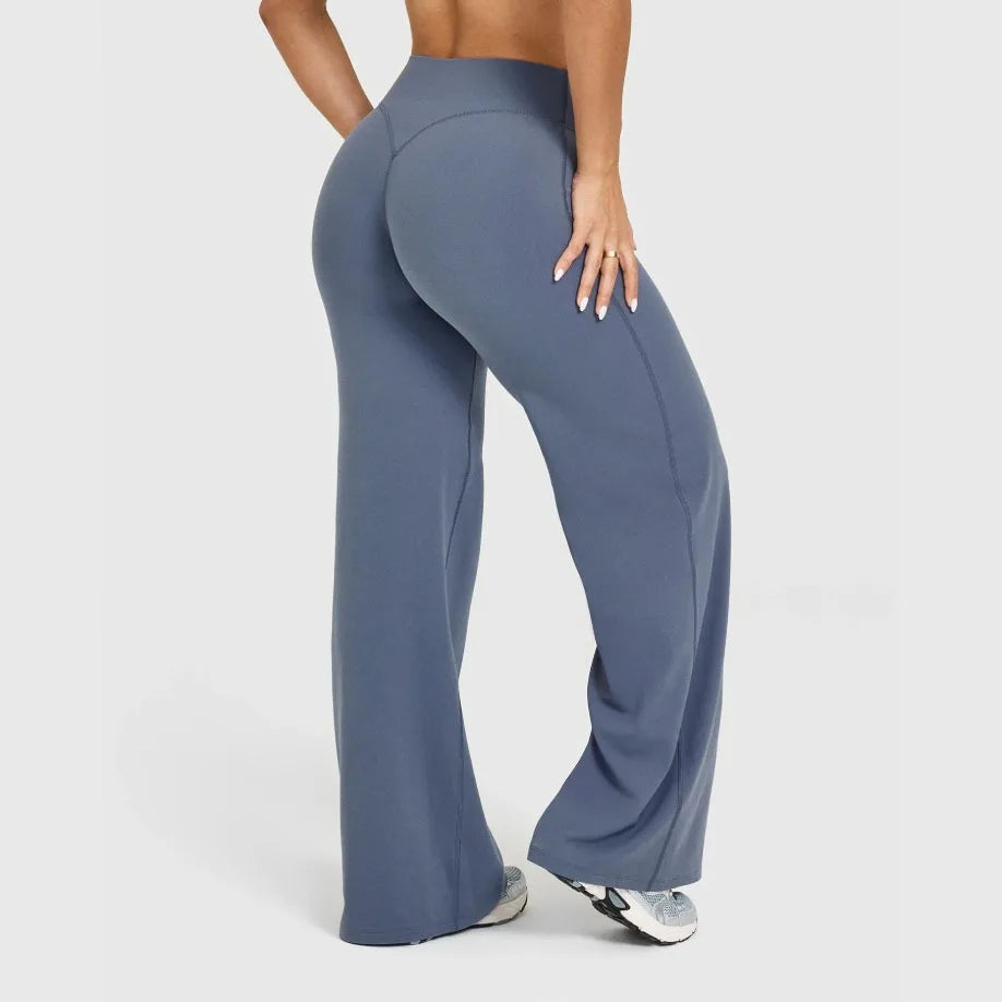 A model is wearing dark blue high-waist yoga pants while standing.