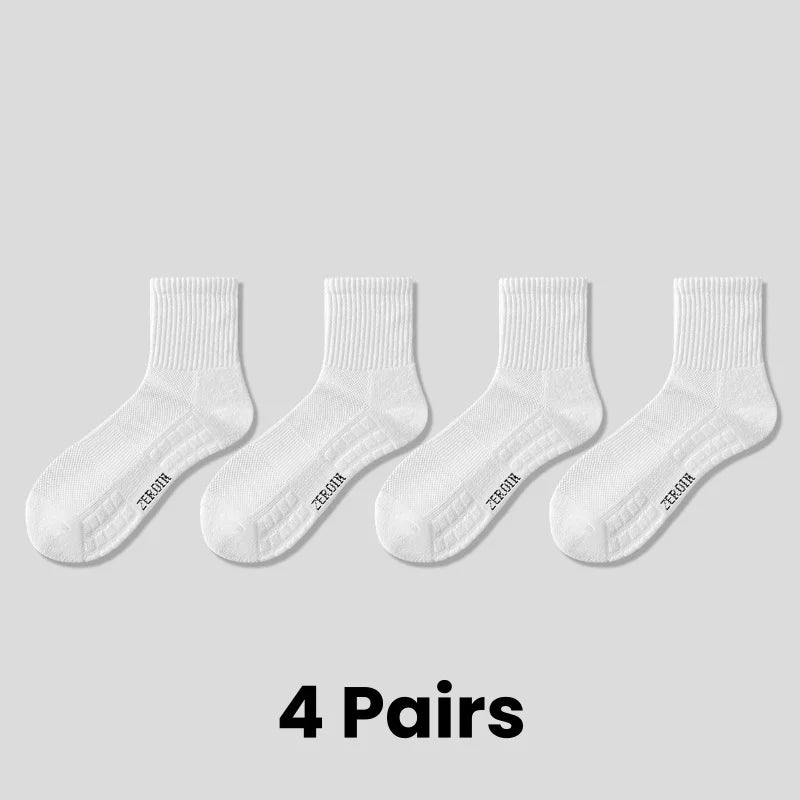 Four pairs of white breathable sports performance socks laid out flat.
