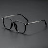 A pair of black retro anti-blue light glasses resting on a dark surface.