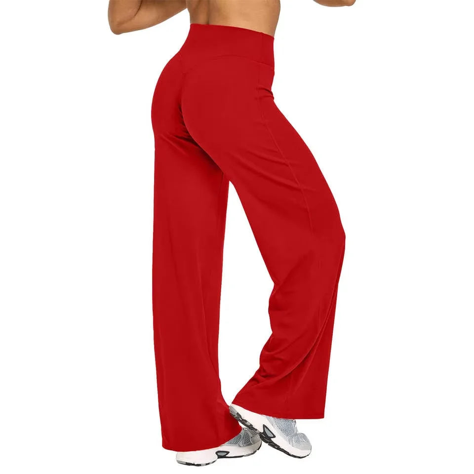 A model is wearing red high-waist yoga pants and gray athletic shoes.