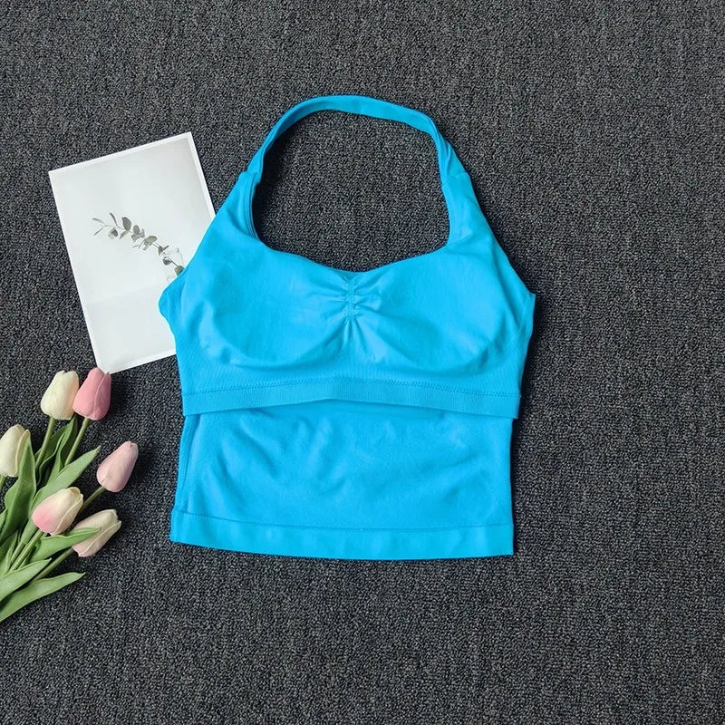 Haut bandeau bleu vif et sans coutures pour yoga et fitness, exposé sur un tissu gris foncé avec des tulipes roses et blanche