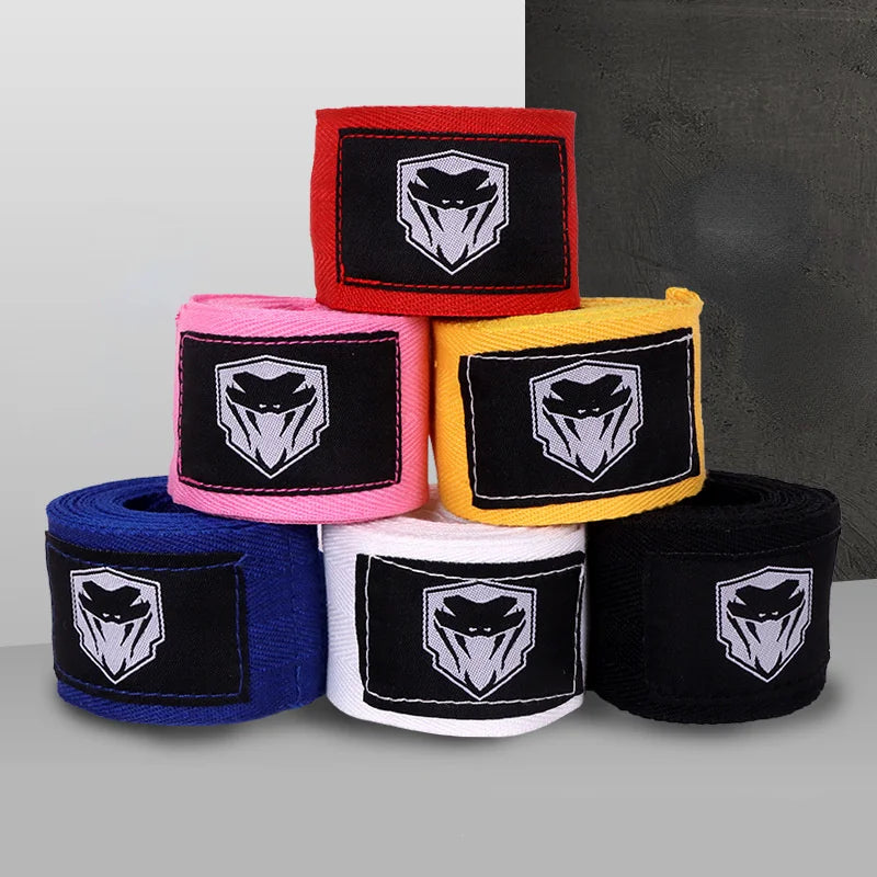 A stack of professional cotton boxing hand wraps in red, pink, yellow, blue, and black featuring a white stylized skull desig