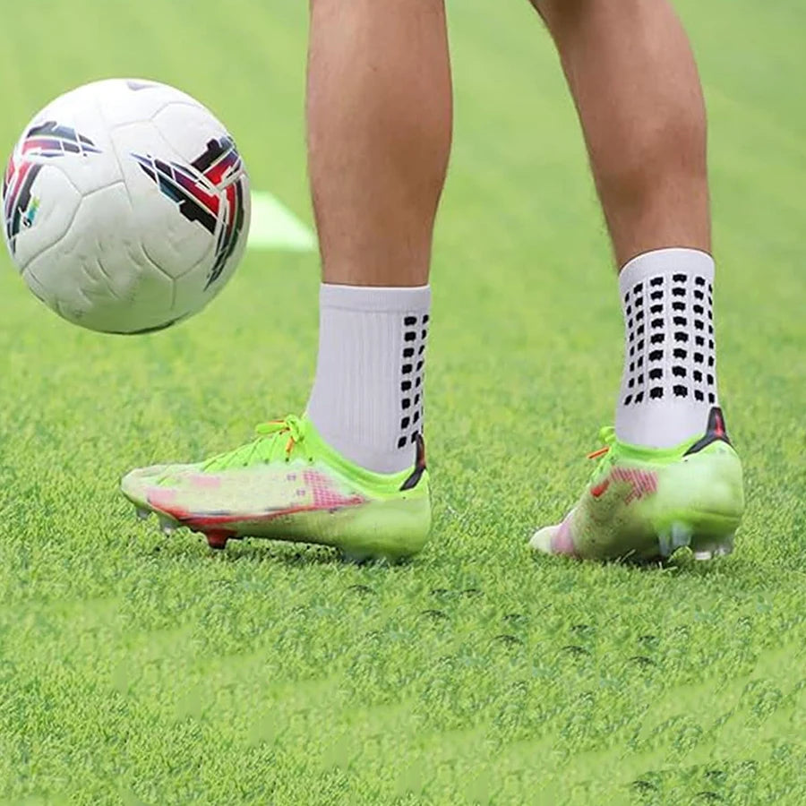 Nahaufnahme eines Fußballs und eines Paar athletischer Griffhose auf einem grünen Feld.