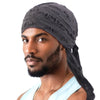 A man wearing a black distressed pirate style durag head wrap and light blue shirt.