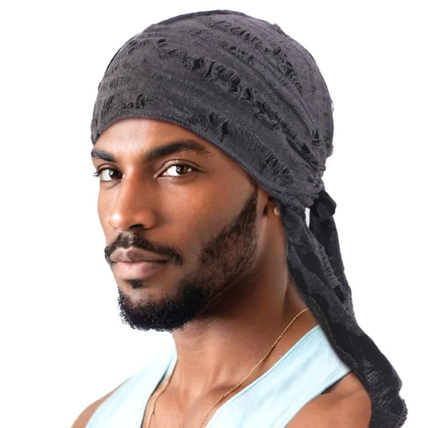 Un homme portant un foulard pirate noir usé et une chemise bleu clair.