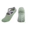 A pair of olive green silicone anti-slip pilates and yoga socks shown from the side.