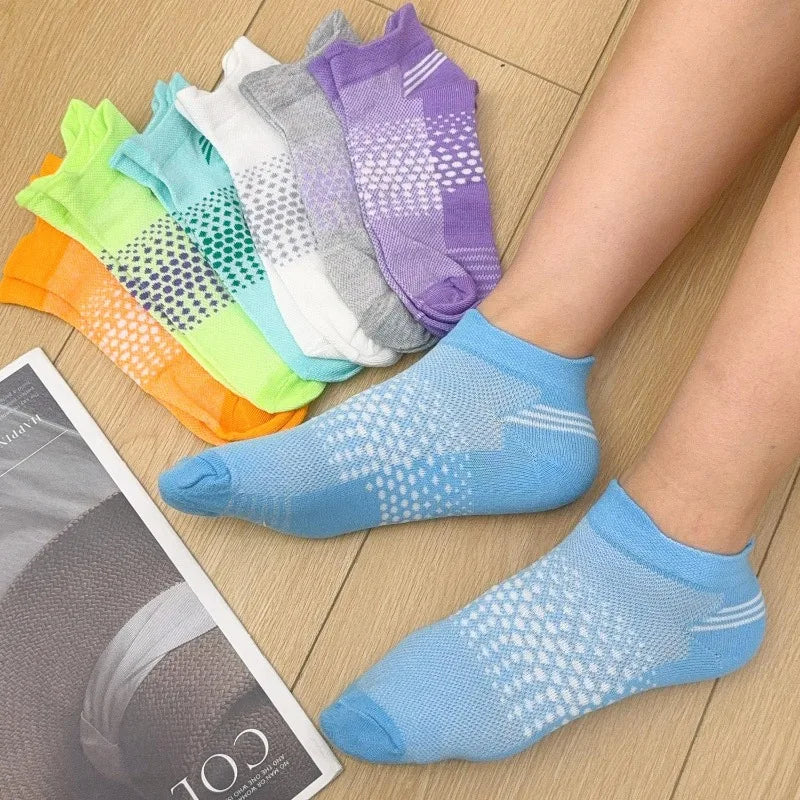 A collection of colorful breathable mesh ankle socks displayed on a wooden surface.