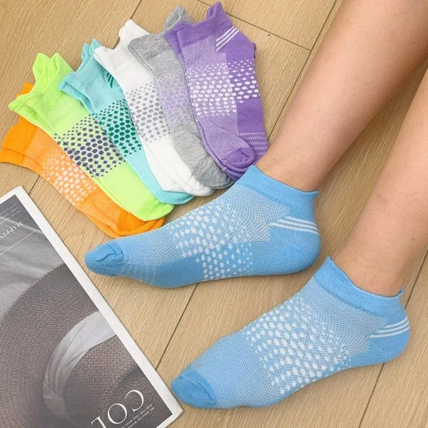 A collection of colorful breathable mesh ankle socks displayed on a wooden surface.
