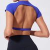 A woman wearing a royal blue fitness crop top yoga and gym t-shirt, shown from the back.