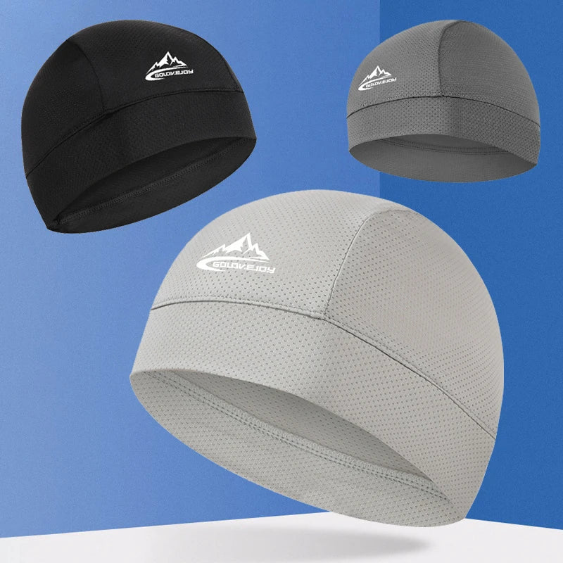 Un set de tres gorros de calavera transpirables en negro, gris y gris claro, mostrados contra un fondo azul.