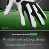 A close-up view of a white and black glove with a hook and loop design resting on a green golf course.