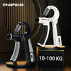 A pair of white and black adjustable hand grip strengtheners displayed on a wooden stand.