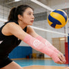 Une athlète féminine portant des manches de volleyball roses se prépare à jouer au volleyball.