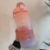 Botella de agua aislada rosa motivacional con tapa de pajita, sostenida contra un fondo blanco.