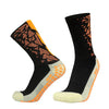 A pair of black sports socks with orange and white anti-slip silicone accents.