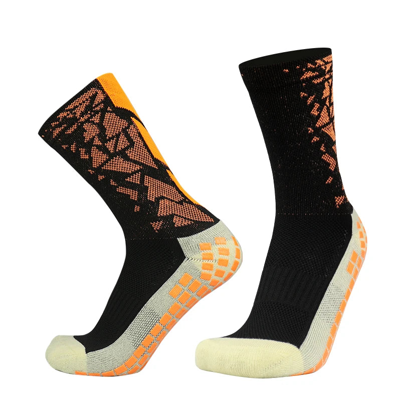 A pair of black sports socks with orange and white anti-slip silicone accents.