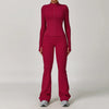 A woman wearing a long-sleeved maroon yoga sports set consisting of a top and pants.