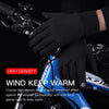 Black high-density cycling gloves being worn on a hand, with a blue bicycle visible in the background.