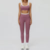 Eine Frau trägt ein zweiteiliges mauve Yoga- und Trainingsanzugset mit croppedem Oberteil und passenden Leggings.