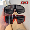 A hand holds two pairs of black and red cycling sunglasses for outdoor sports.