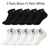 A collection of ten pairs of ankle socks, five black and five white, laid out for display.