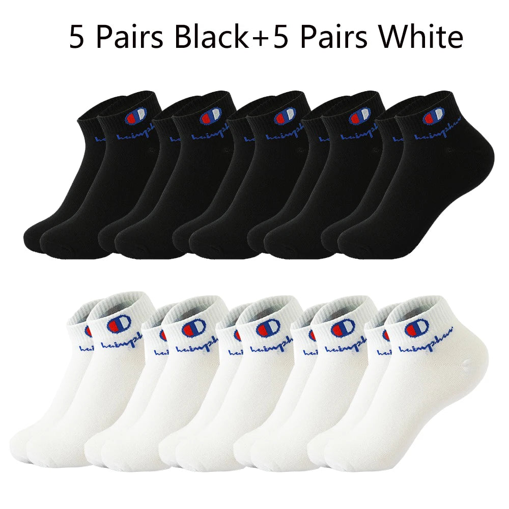 A collection of ten pairs of ankle socks, five black and five white, laid out for display.