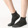 A close-up of a pair of black men's cotton blend ankle socks worn on a person's lower leg.