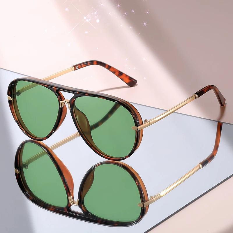 Pair of brown tortoiseshell gradient aviator sunglasses resting on a light surface.