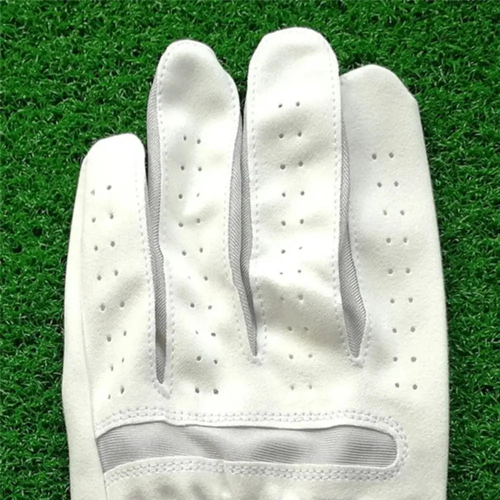 A close-up view of a white microfiber men's golf glove resting on green grass.