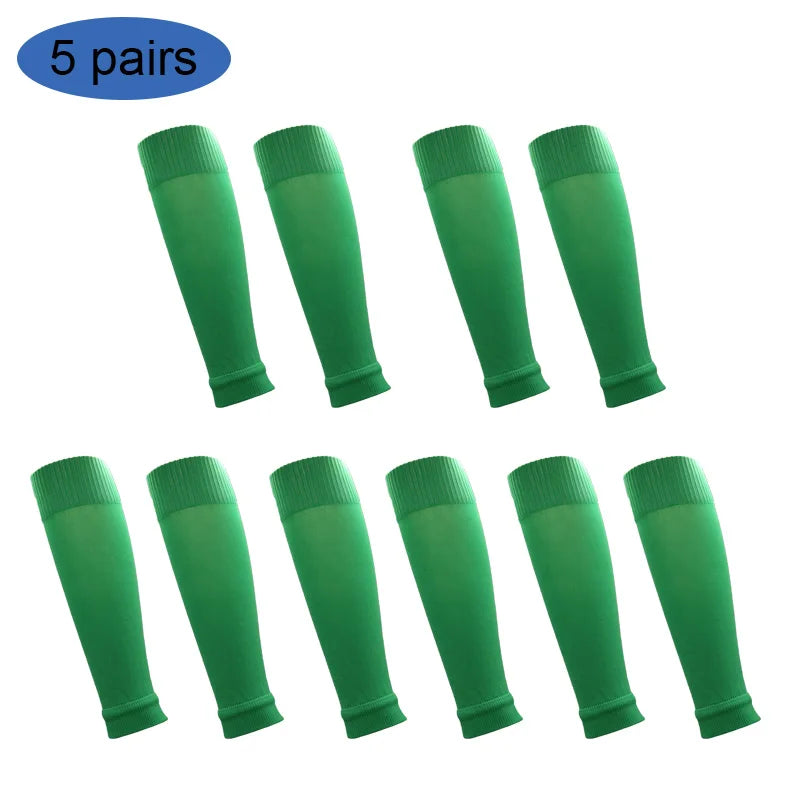 Five pairs of green football shin guards for leg protection