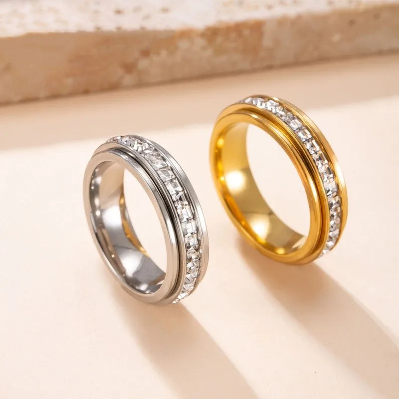 A pair of gold and silver statement rings featuring CZ gemstones displayed on a light background.