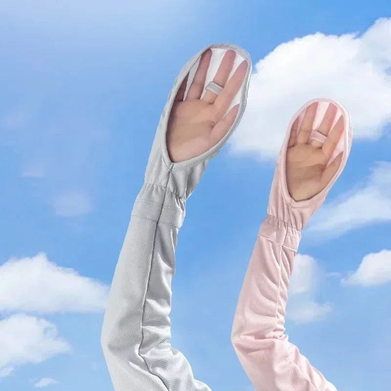 A hand wearing a light gray UV protection arm sleeve against a blue sky with white clouds.