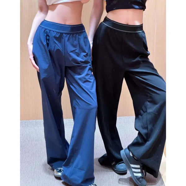 Un pantalon de yoga ample pour femme, bleu foncé et noir, porté par un mannequin.
