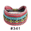 A colorful, patterned boho knotted cotton headband featuring geometric designs in red, black, and teal.