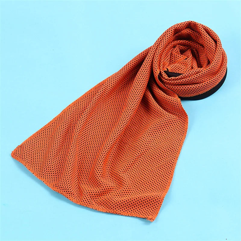 Orange microfiber cooling towel rolled up on a light blue background.