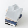 A stack of six pairs of men's combed cotton socks in various shades of gray and blue.