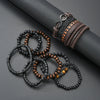 A collection of dark and amber beaded leather bracelets and a woven leather wristband resting on a dark surface.