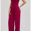 A woman models a deep magenta women's premium fitness tracksuit in a fitted long-sleeved top and matching trousers.