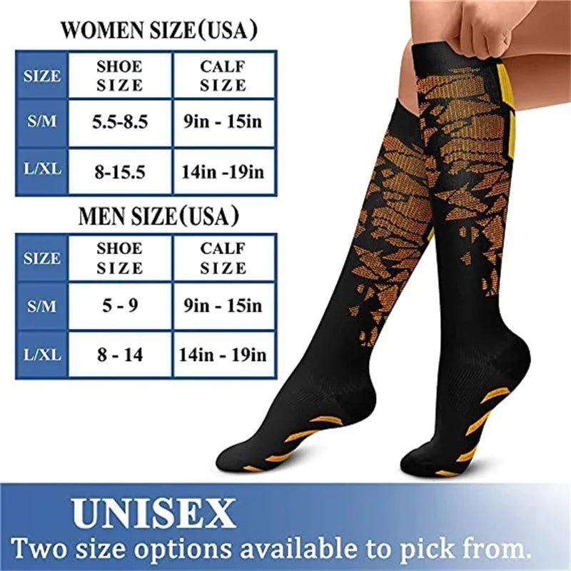 A pair of black graduated compression socks with gold patterned accents shown on a person's leg.