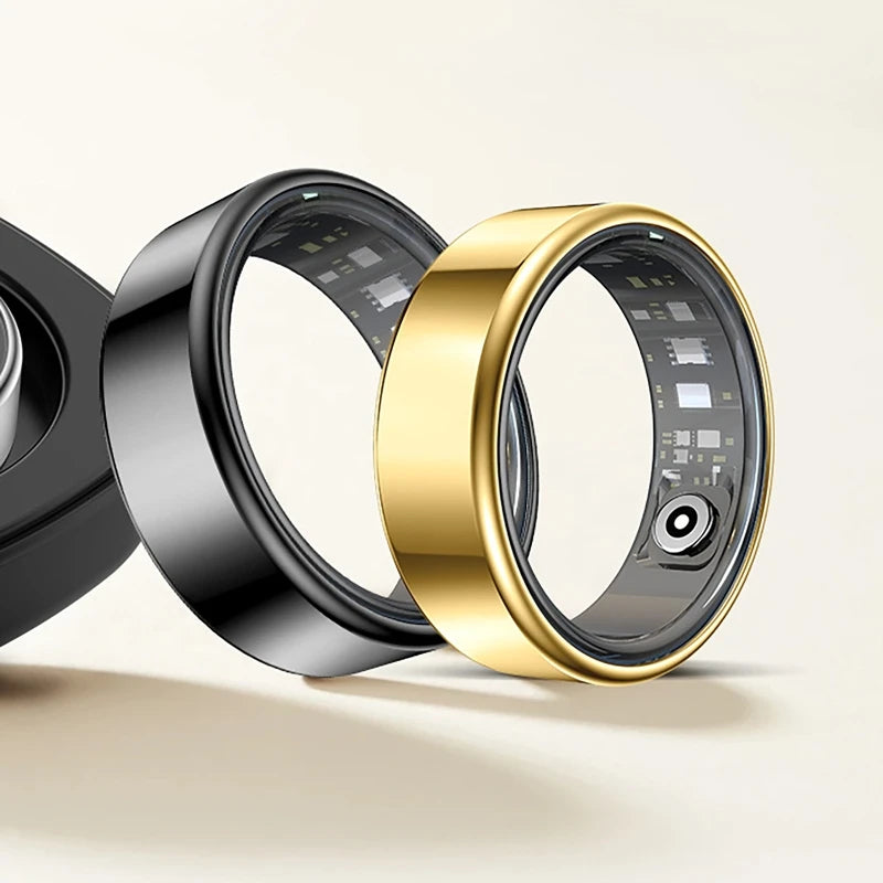 A close-up of a gold and black smart health ring fitness tracker displayed against a light background.