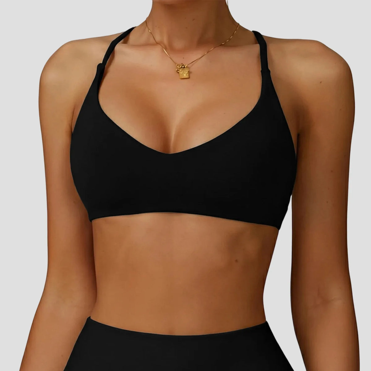 A woman wearing a black high-support sports bra for yoga and fitness.