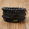 Stapel handgemachter schwarzer Lederblättchen-Feder-Armbänder auf Holzoberfläche.